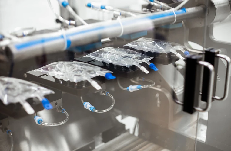 Eine Maschine stellt Infusionsbeutel mit destilliertem Wasser her.