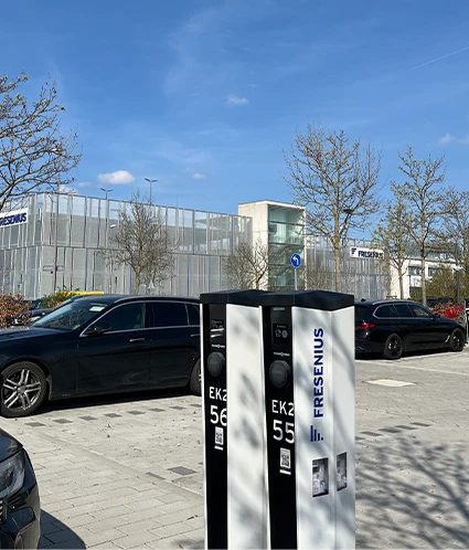 Ein Parkplatz auf dem eine Elektro Auto Ladestation im Fokus ist.