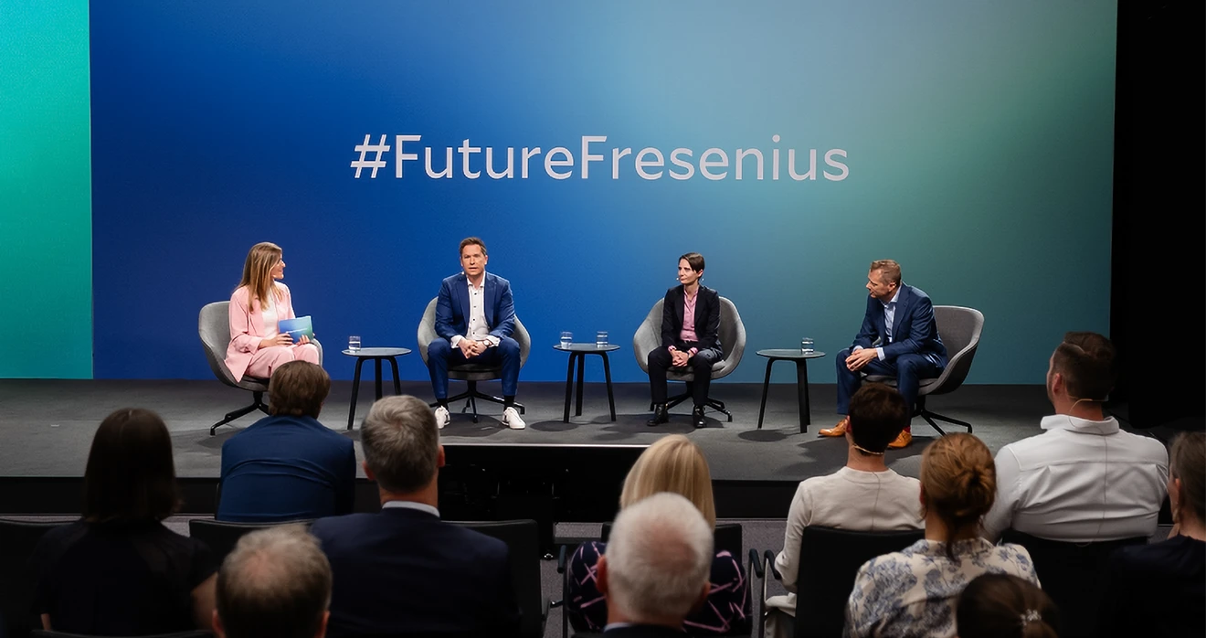 Ein Ausschitt aus #FutureFresenius, der vier Personen auf einer Bühne bei einer Diskussion zeigt mit Publikum davor.