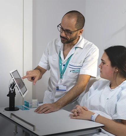 Ein Mann, erklärt einer Patientin etwas auf einem Tablet.