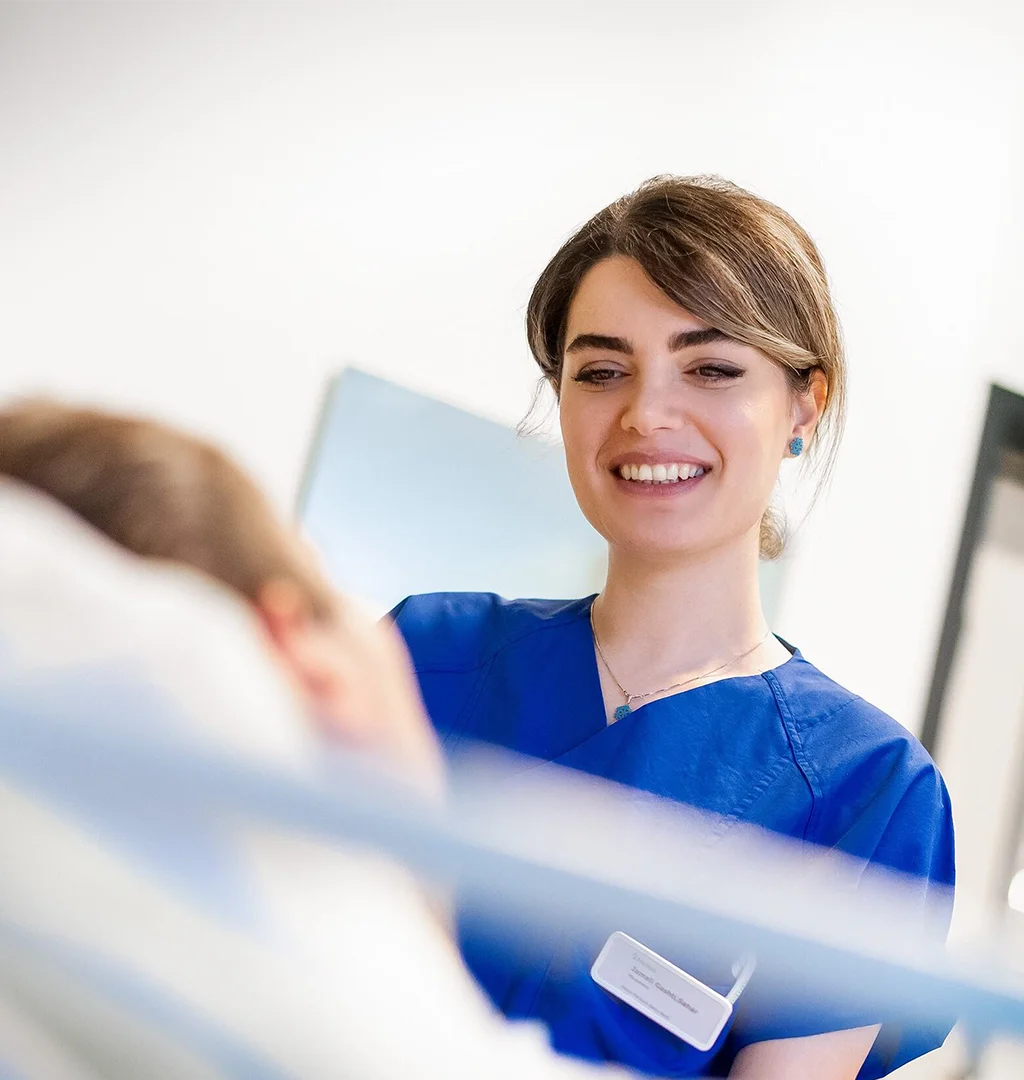 Eine Krankenpflegerin lächelt einem Patienten zu