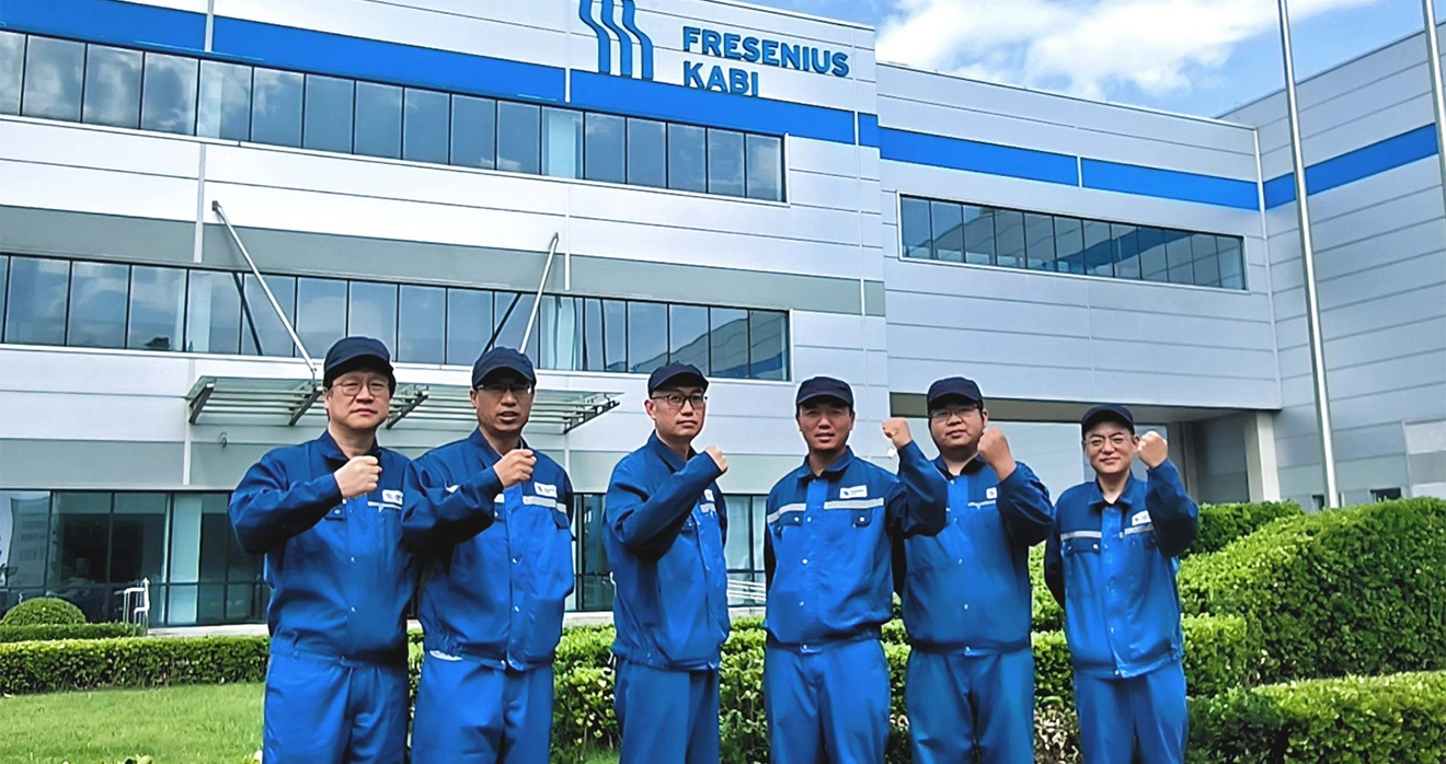 Six men standing in front of a Fresenius Kabi Building