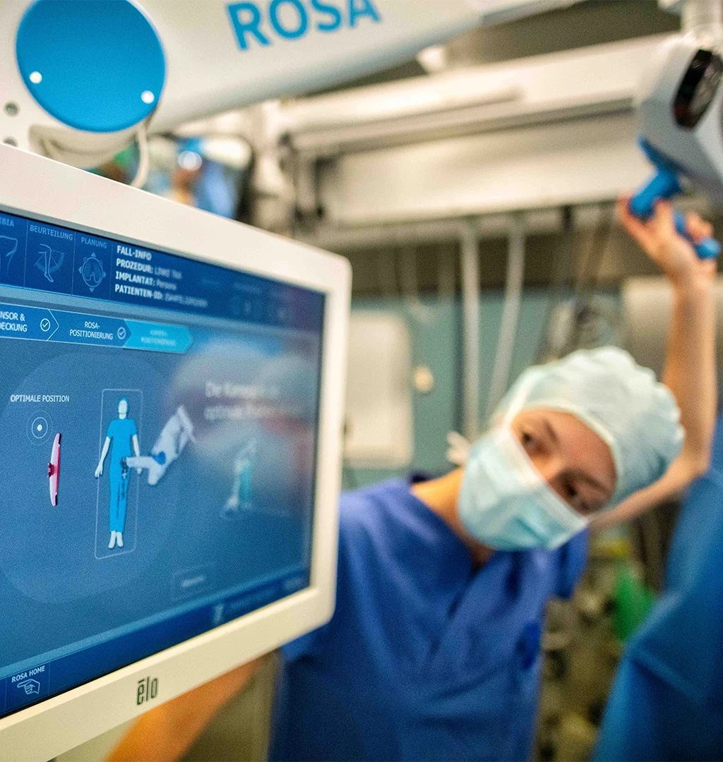 The image shows a healthcare worker looking on a screen.