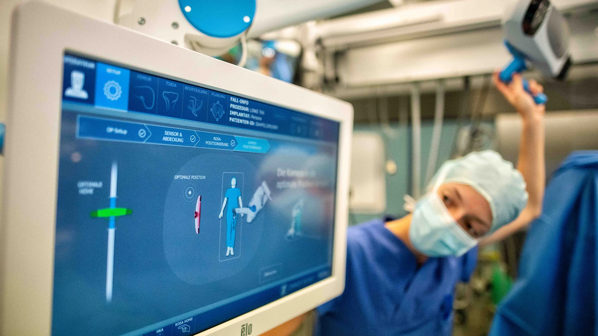 The image shows a healthcare worker looking on a screen.