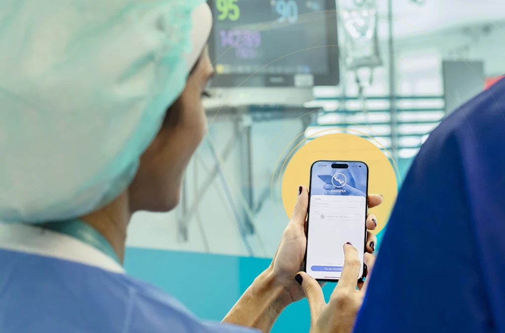 The image shows a healthcare professional. interacting with a smartphone in what appears to be an operating room or similar healthcare setting.